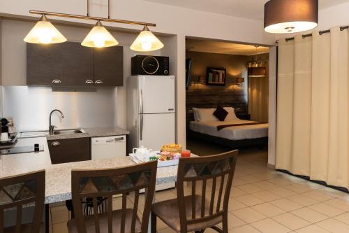 a kitchen with a table and chairs and a room with a bed at Eclipse Belle Etoile Appart'h&ocirc;tel in Cayenne