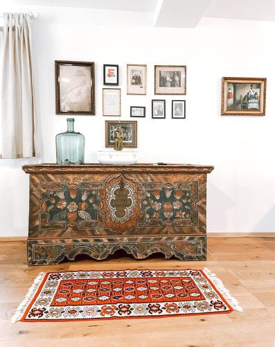 an old wooden dresser in a room with a rug at Exquisites Übernachten in der ältesten Stadt Österreichs in Enns