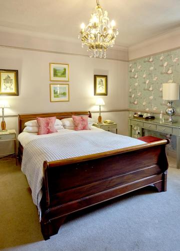 a bedroom with a large bed with pink pillows at The Ormond At Tetbury in Tetbury