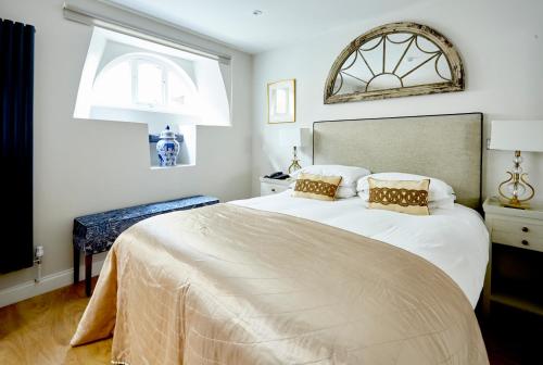 a bedroom with a large bed and a window at The Ormond At Tetbury in Tetbury