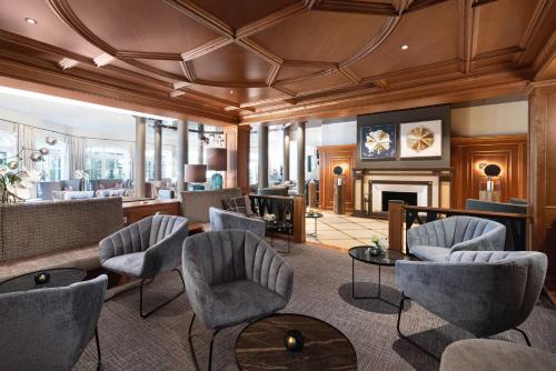 a living room with chairs and a fireplace at Wellness- & Sporthotel Jagdhof in Röhrnbach
