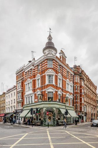 a large red brick building on a city street at Stay Kula London - Fitzrovia Newman St in London