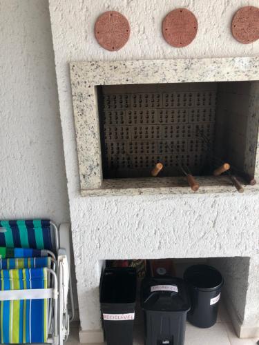 a stone fireplace with two trash cans and two buckets at Condominio Villas do Campeche in Florianópolis