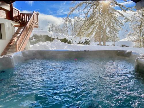 uma banheira de hidromassagem na neve num quintal em Chalet Melchior em Villars-sur-Ollon