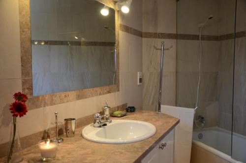 a bathroom with a sink and a mirror and a tub at The Sea at Your Fingertips in Cascais