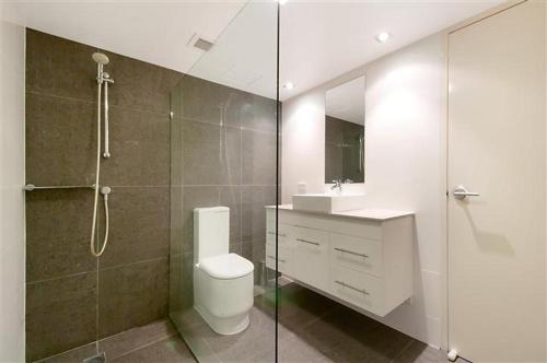 a bathroom with a shower and a toilet and a sink at Beaconlea in Gold Coast