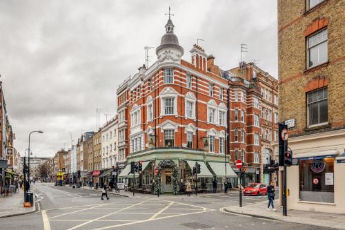 a large red brick building on a city street at Stay Kula London - Fitzrovia Newman St in London