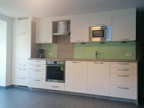 cocina con armarios blancos y microondas en Ferienhaus Sporer en Iselsberg