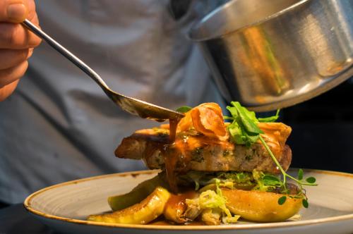 a person eating a plate of food with a fork at Boutique Hotel, Restaurant & Wellness Westerburcht in Westerbork