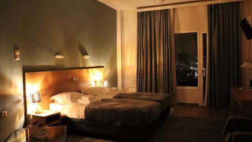 a hotel room with a bed and a window at Hara Hotel in Chalkida