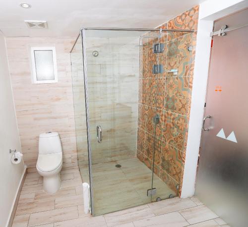 a shower stall in a bathroom with a toilet at Royal Decameron Cornwall Beach - All Inclusive in Montego Bay