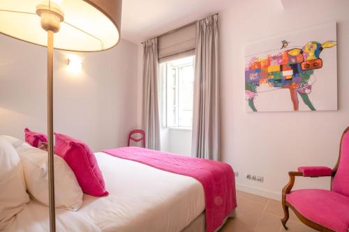 una camera con letto, lampada e sedia di Les Demeures du Tonnelier, Maison Rue a Saint-Romain