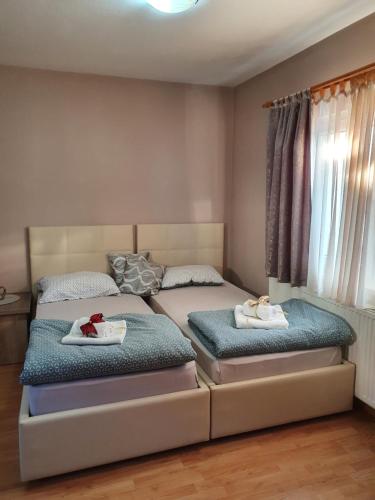 two beds in a bedroom with towels on them at Apartman "MILLAN" in Prijedor