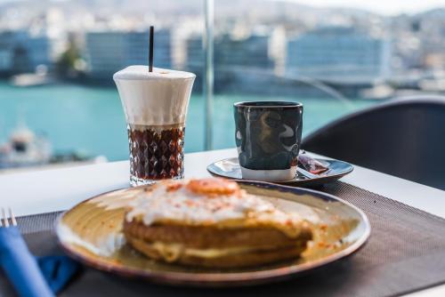 a plate with a donut and a cup of coffee on a table at Hara Hotel in Chalkida