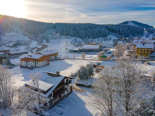 a town covered in snow with the sun in the background at Bergidyll Top 1 Gartenwohnung in Ramsau am Dachstein
