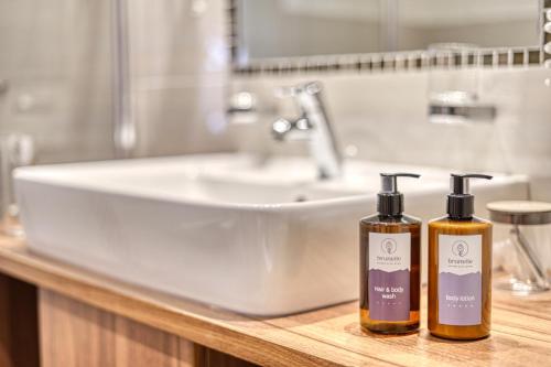 two bottles ofodorizers sitting on a counter next to a sink at Brunelle Seiser Alm Lodge in Alpe di Siusi