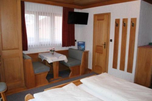 Schlafzimmer mit einem Bett, einem Tisch und einem TV in der Unterkunft Beim Hanslbauer in Chieming