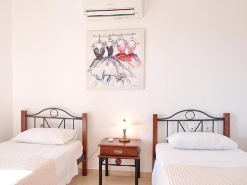 a bedroom with two beds and a table with a lamp at Villa Estia Spartia Kefalonia in Kefallonia