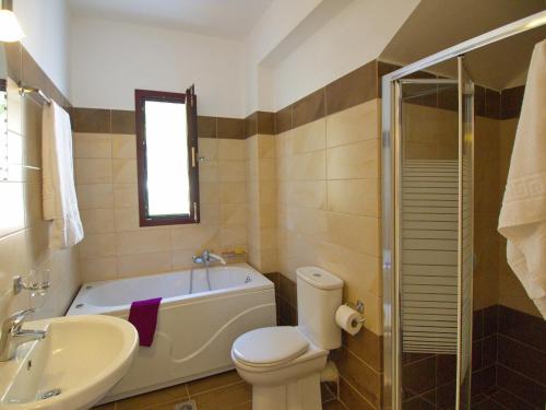 a bathroom with a tub and a toilet and a sink at Villa Estia Spartia Kefalonia in Kefallonia