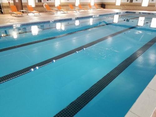 a large swimming pool with blue water and chairs at Holiday Inn Express Hotel & Suites Sheldon, an IHG Hotel in Sheldon