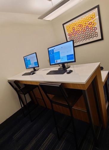 a desk with two computers on top of it at Holiday Inn Express Hotel & Suites Sheldon by IHG in Sheldon