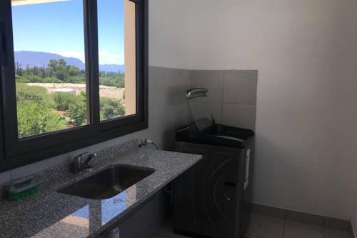 baño con lavabo, ventana y cubo de basura en CALCHAQUÍ 5 ideal para una estadía inolvidable! en Cafayate