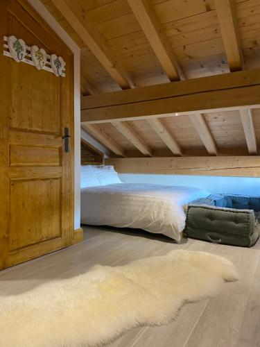 Bett in einem Zimmer mit Holzdecke in der Unterkunft Chalet Beaufort in Saint-Martin-de-Belleville