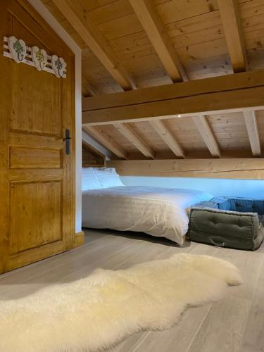 a bed in a room with a wooden ceiling at Chalet Beaufort in Saint-Martin-de-Belleville