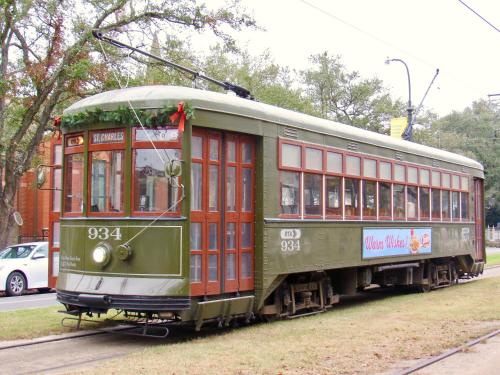 an old green and red trolley car on a street at St Charles Inn, Superior Hotel in New Orleans