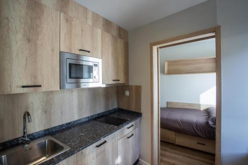 cocina con fregadero y microondas en micampus Bilbao Student Residence, en Bilbao