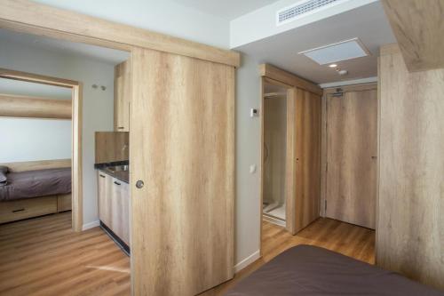 Habitación con puertas correderas de madera y cama en micampus Bilbao Student Residence, en Bilbao