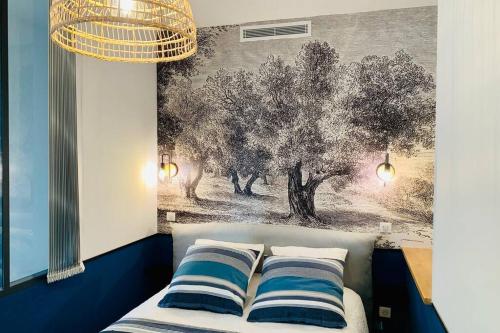 un letto con due cuscini e un dipinto sul muro di Le Phocéen : T4 balcon vue Vieux-Port a Marsiglia