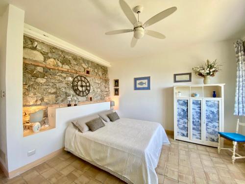 a bedroom with a bed and a stone wall at Villa Don Giovanni Taormina Mare in Taormina