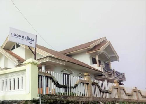 a house with a good karma sign in front of it at Good Karma Bromo Guesthouse in Bromo