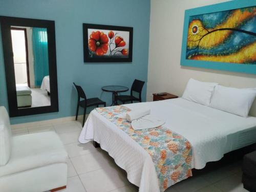 1 dormitorio con cama, sofá y espejo en Hotel Casablanca CHIPIPE, en Salinas