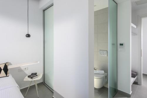 a bedroom with a glass door leading into a bathroom at Cocoon Luxury Villas in Hersonissos