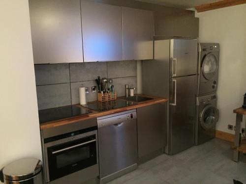 La cuisine est équipée d'un évier et d'un réfrigérateur. dans l'établissement Appartement Courchevel le Praz, à Courchevel
