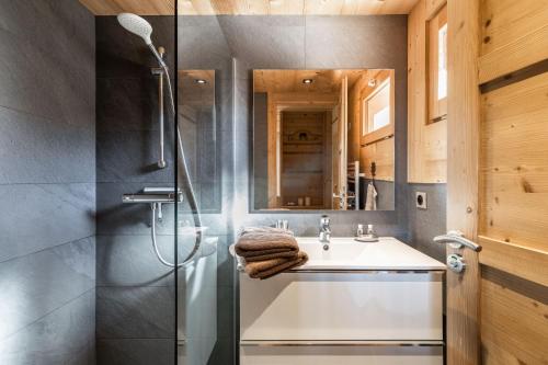 y baño con lavabo y ducha. en Chalet Socali Le Grand Bornand, en Le Grand-Bornand