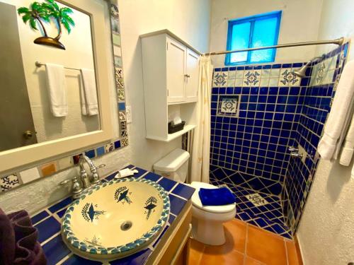 a blue tiled bathroom with a sink and a toilet at La Felicidad in Puerto Peñasco