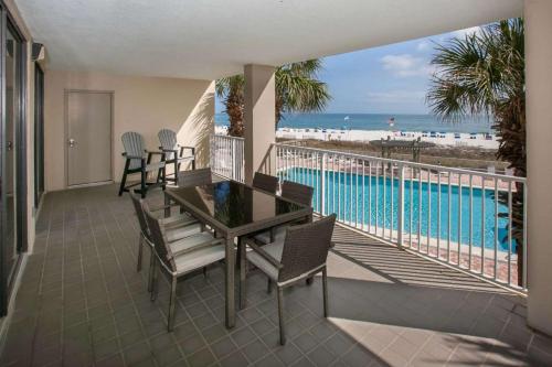 un balcon avec une table et des chaises et une piscine dans l'établissement White Caps 206, à Romar Beach