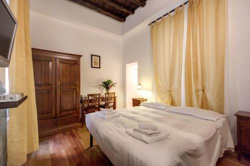 a bedroom with a white bed with towels on it at Nova Domizia in Rome