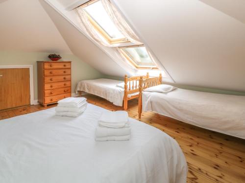 a attic bedroom with two beds and a window at Sea Peeps in Paignton