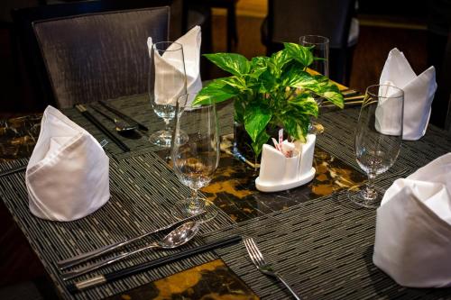 a table with glasses and a potted plant on it at Chengdu Joyhub Air Hotel in Chengdu