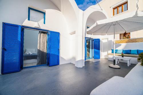 a white building with blue doors and an umbrella at Casa Maritina private residence in Fira