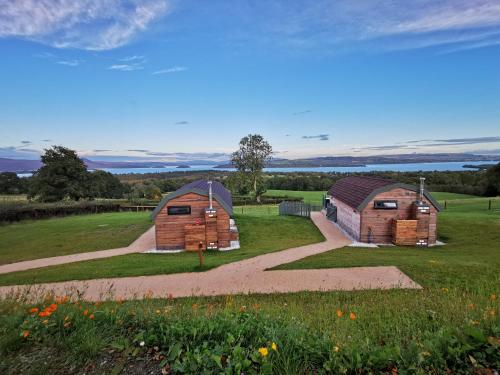 two barns in a field with a path at Bonnie Barns - Adults Only Luxury Lodges with hot tubs in Luss