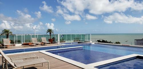 a swimming pool with a view of the ocean at EXCELENTE FLAT 2 QUARTOS no BESSA in João Pessoa