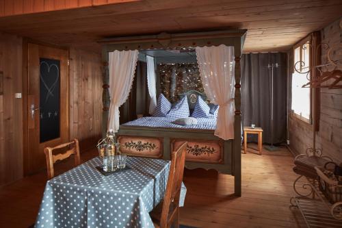 um quarto com uma cama de dossel e uma mesa com uma toalha de mesa em Nostalgie Bed & Breakfast Chrämerhus em Curaglia