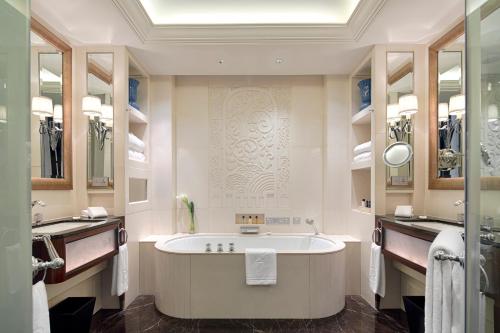 a bathroom with a tub and two sinks at The Peninsula Shanghai in Shanghai