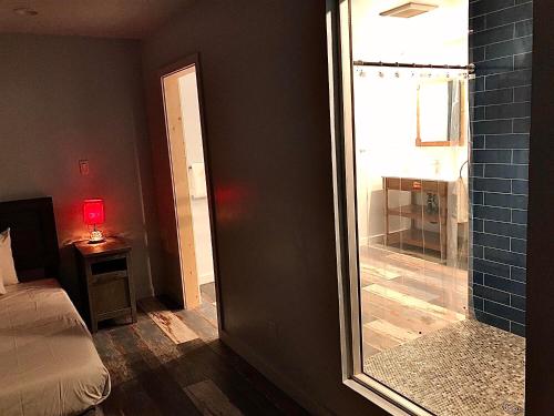 a bedroom with a shower and a mirror and a bed at Tao Cabins in Big Bear City