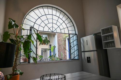 an arched window in a room with a refrigerator at Casa Kali by Barrio México in Guadalajara